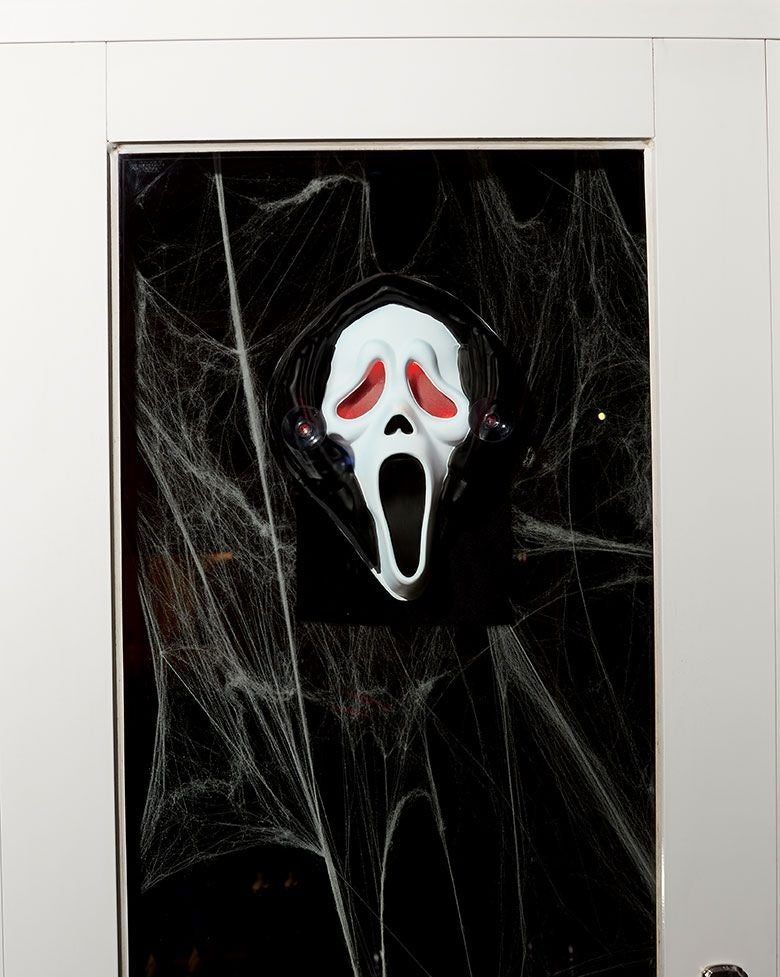 Decoration designed to be hung in your window or on a glass door. Looks like Ghost Face is peeping into your home, or peering out.