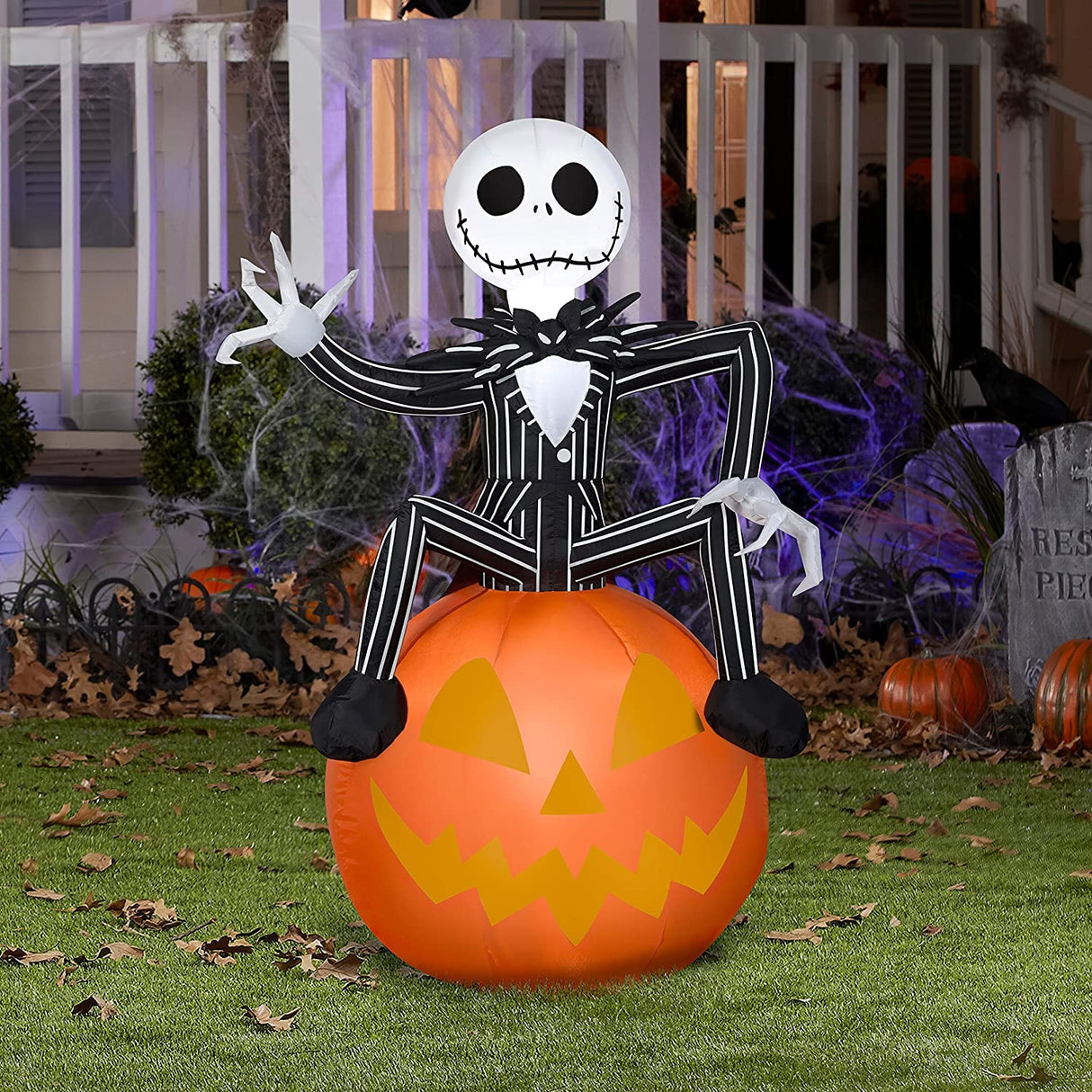 Halloween inflatable shaped like Jack Skellington from the movie The Nightmare Before Christmas. He's sitting on a jack-o-lantern and waving.