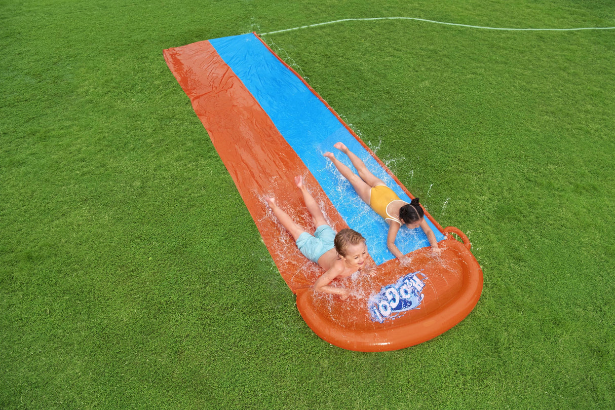 A slip n slide with two lanes that lead into a splash pad.