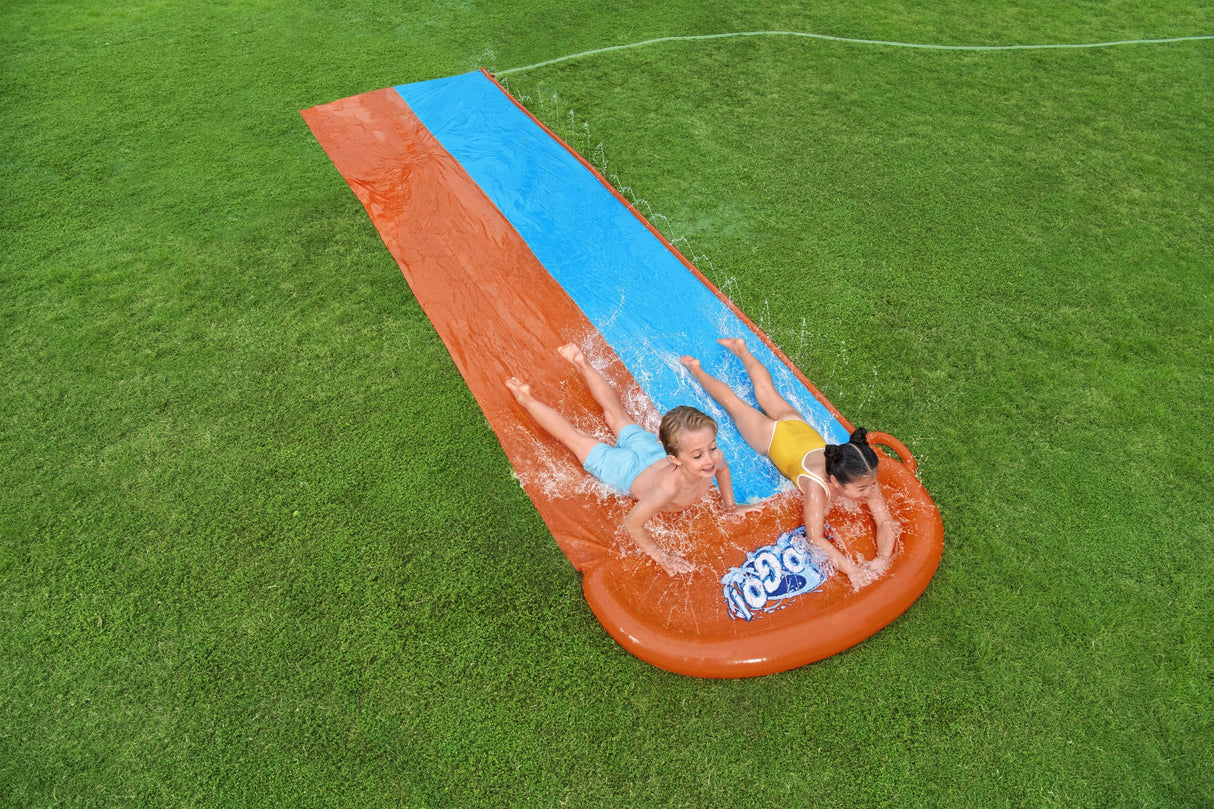 A slip n slide with two lanes that lead into a splash pad.