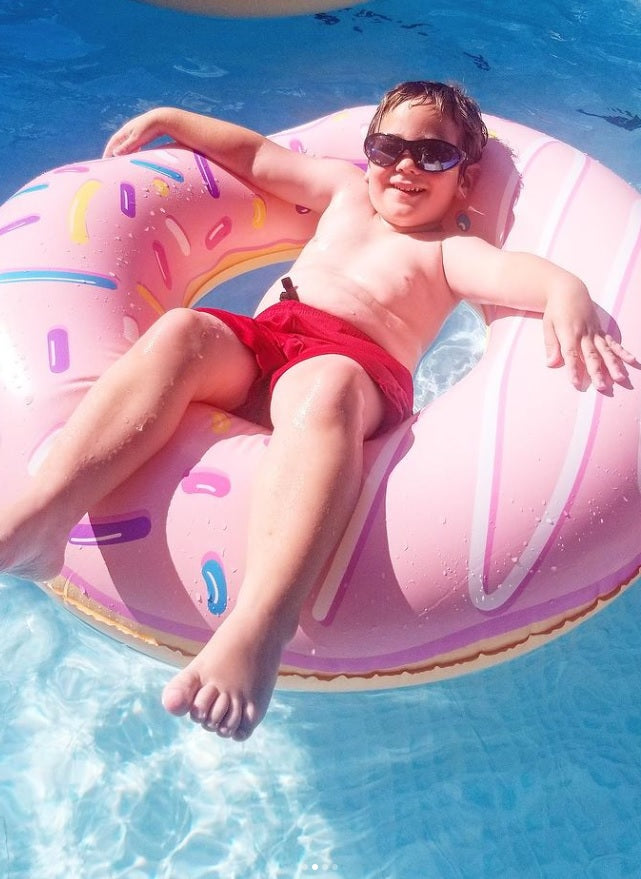 Double-bit, donut-shaped inner tube with pink frosting and a sprinkled design.