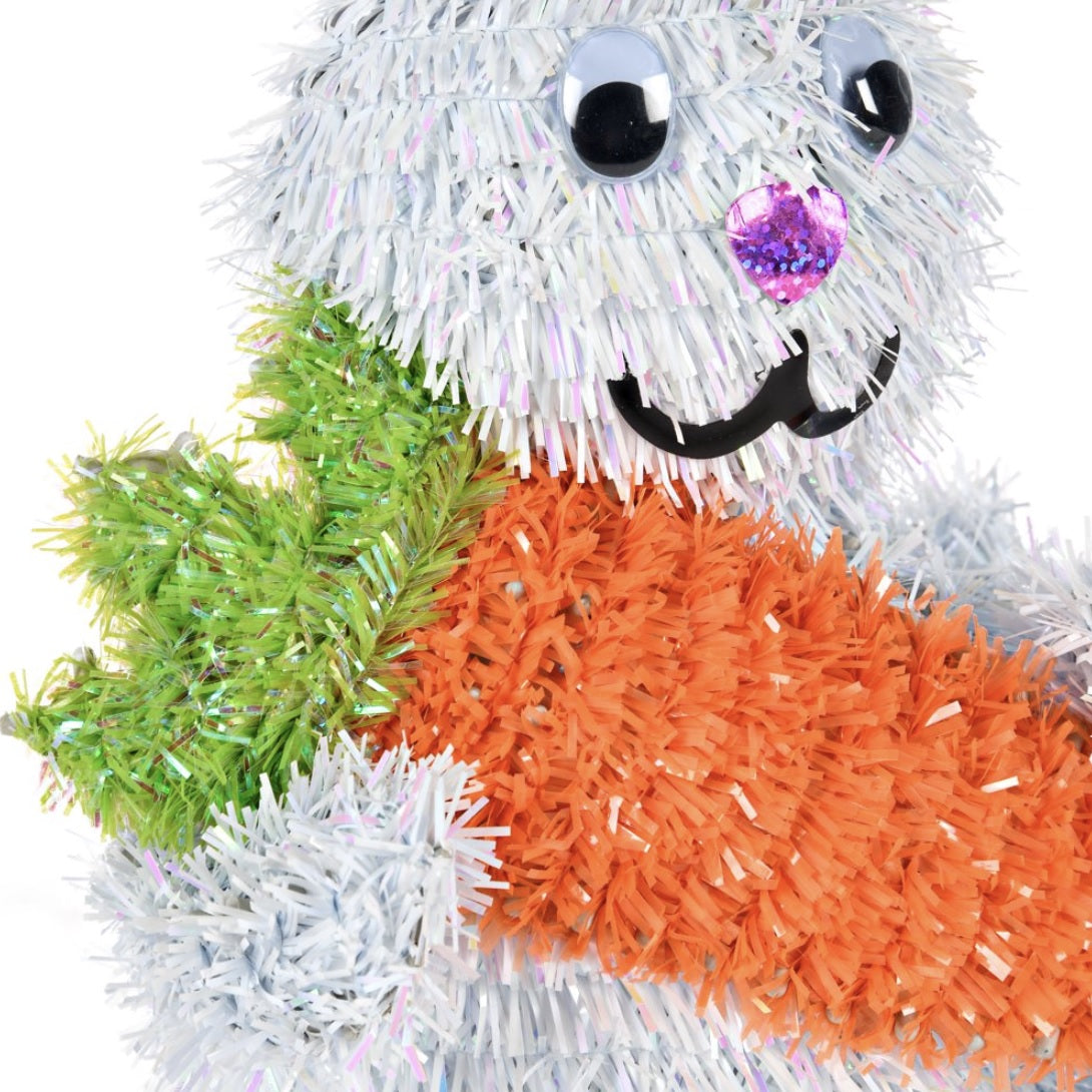 An up close view of a tinsel bunny holding a carrot