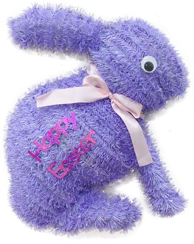 A purple tinsel tabletop decoration shaped like bunnies that read "HAPPY EASTER" and features a light pink bow around its neck
