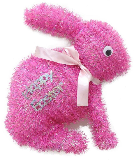 A pink tinsel tabletop decoration shaped like bunnies that read "HAPPY EASTER" and features a light pink bow around its neck