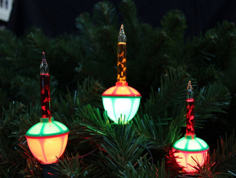 Red, green and orange bubble lights being displayed on a tree.