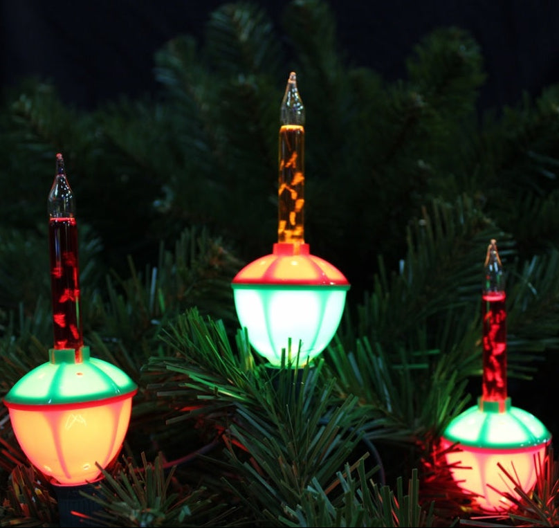 Red, green and orange bubble lights being displayed on a tree.