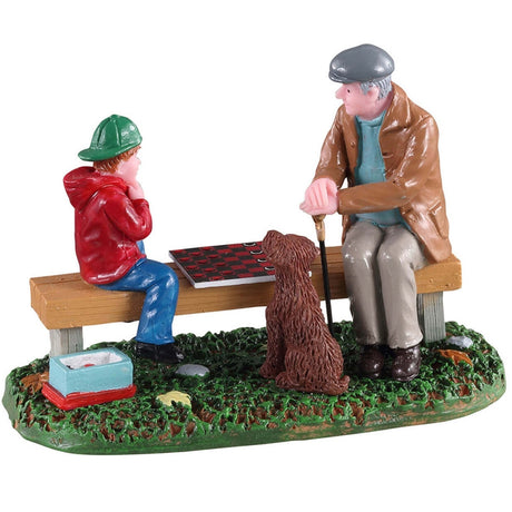 Polyresin figurine for a Lemax Village display. Designed to look like a Grandpa teaching a young child how to play checkers on a wooden bench while a dog watches