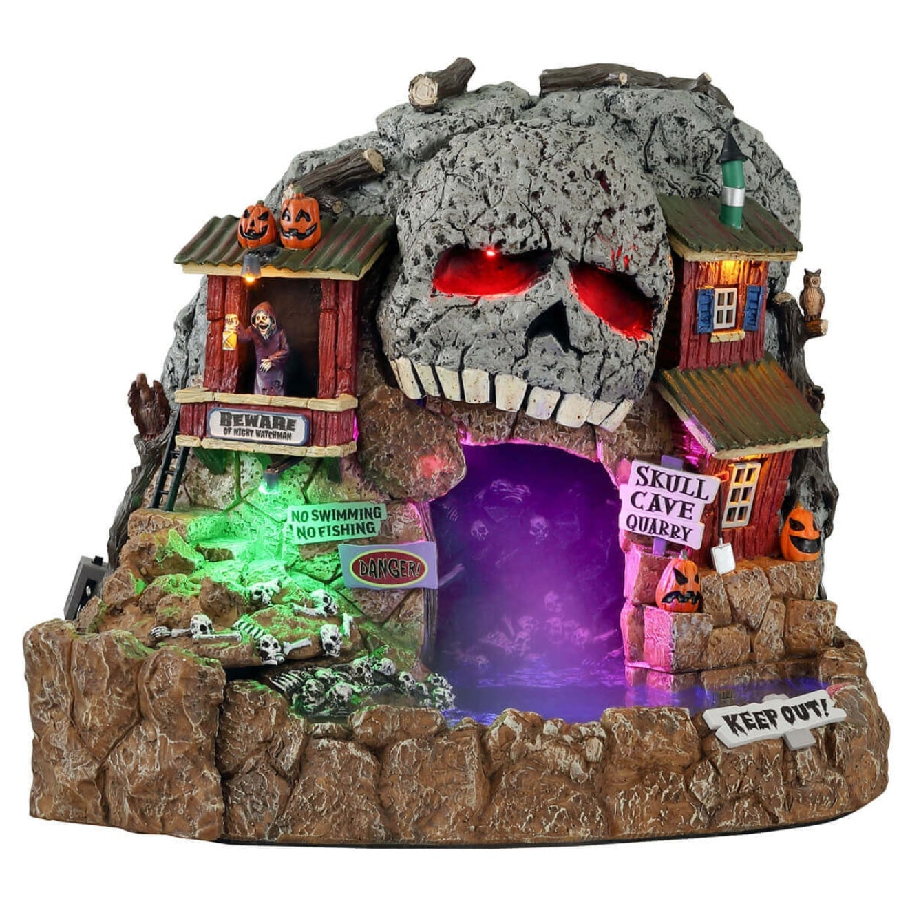 Polyresin village accent for a Lemax display. Designed to look like a rock quarry cave. The top of the cave is designed to look like the top of a skull with glowing red eyes. There are bones and skeletons and pumpkins and a sign that reads "KEEP OUT!" Inside the cave there's a purple fog and you can very faintly see skeletons.