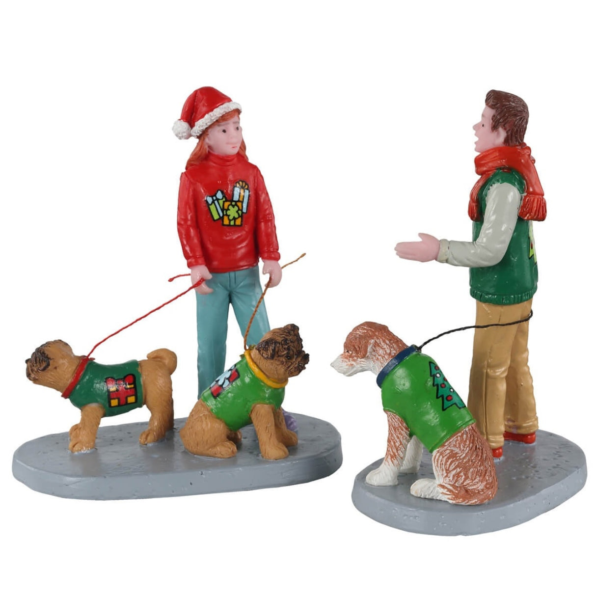 Polyresin figurines for a Lemax Village display. One figure is designed to look like a girl walking two dogs. One figure is designed to look like a dad walking one dog. Everyone is wearing an ugly Christmas sweater