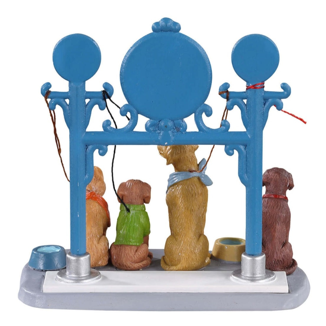 Polyresin figure for a Lemax display. Designed to look like a blue station for dogs to be tied up while their owners shop. The sign reads "Deluxe Dog Parking" and there are four dogs waiting patiently for their owners to return. There are two bowls of water on the ground.