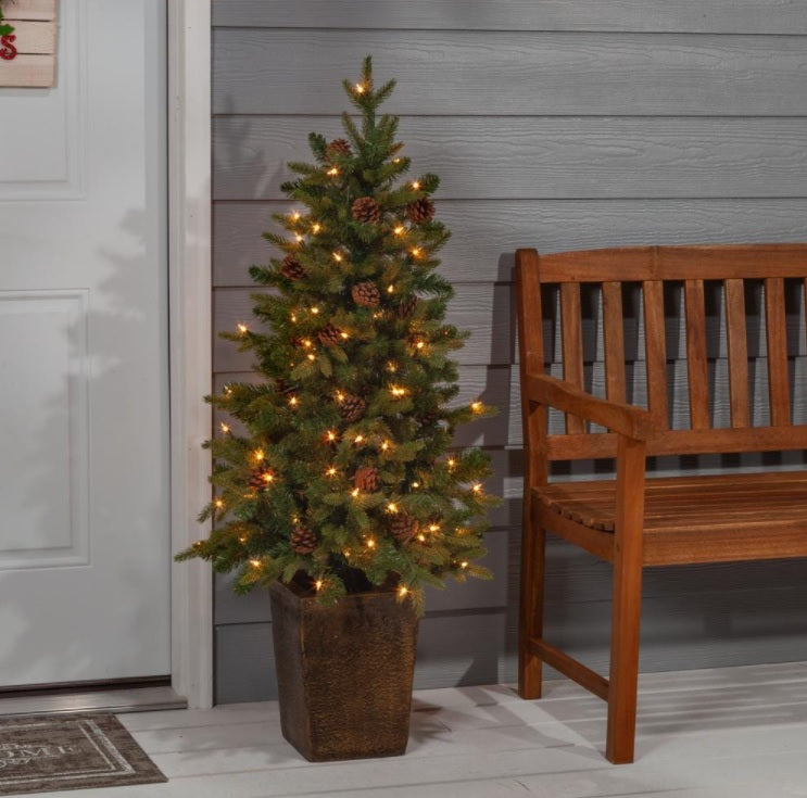 Pre-lit tree in a pot. There are also pine cone accents in the tree.