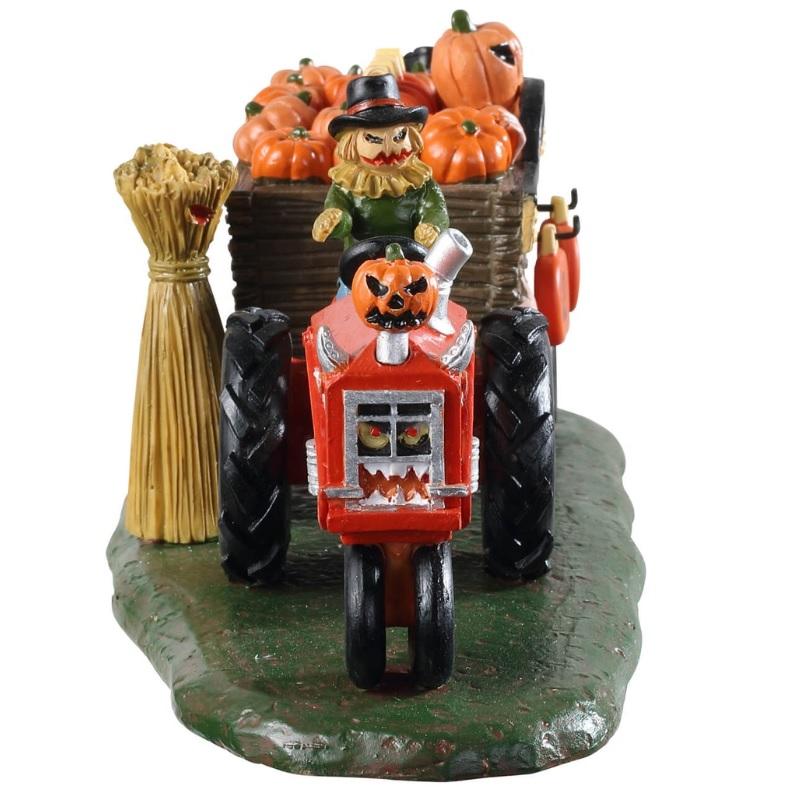 Polyresin village accent for a Lemax display. Designed to look like a scarecrow driving a red tractor with cart attached to it that's full of pumpkins. There's a sign on the side that reads DAYS TO HALLOWEEN and you can change the number.
