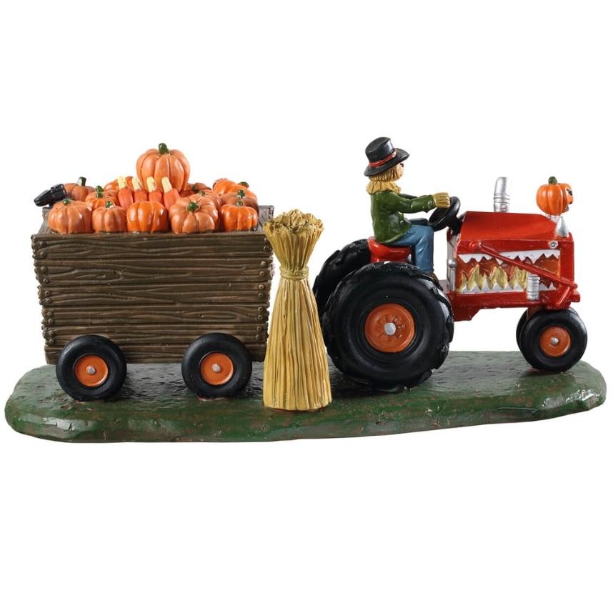 Polyresin village accent for a Lemax display. Designed to look like a scarecrow driving a red tractor with cart attached to it that's full of pumpkins. There's a sign on the side that reads DAYS TO HALLOWEEN and you can change the number.
