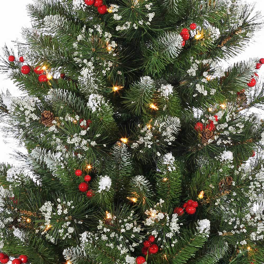 Potted artificial tree. The tree tips are white to look like snow. The lights are warm white and there are red berry accents.