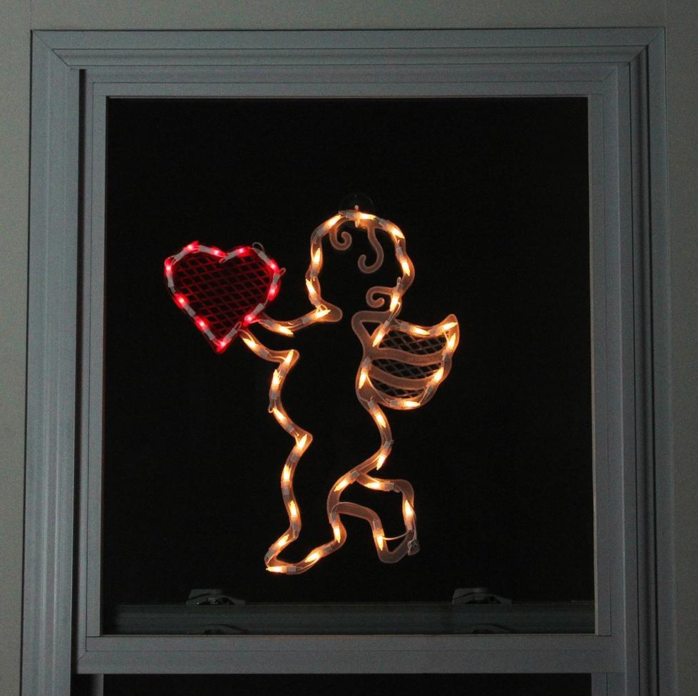 Lighted silhouette decoration shaped like baby Cupid holding a heart.