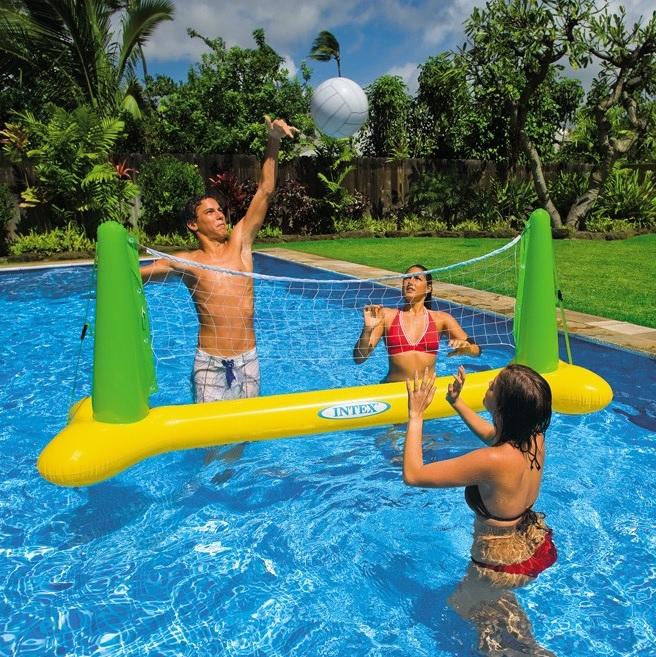 This is a lifestyle image showing three people playing volleyball in the pool.