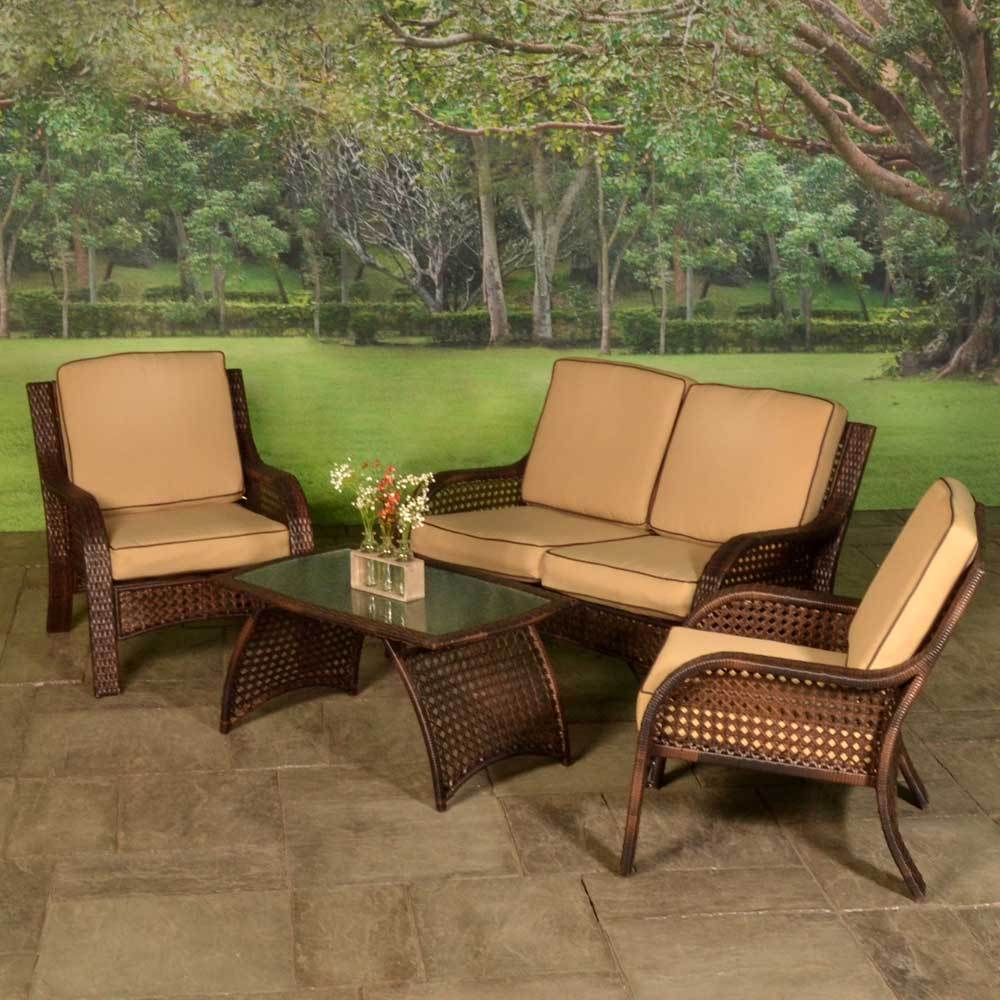 Patio furniture set on a stone patio. The frames are dark brown and the cushions are an orange-ish, tan color.