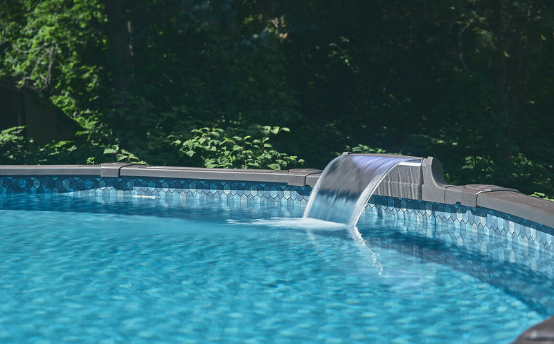 Swimming pool with a water feature surrounded by greenery