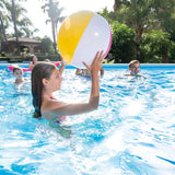 This is a lifestyle image showing a young girl getting ready to throw the beach ball to one of her friends in the pool.