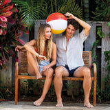 This image shows a man and a woman sitting on a bench holding the beach ball.