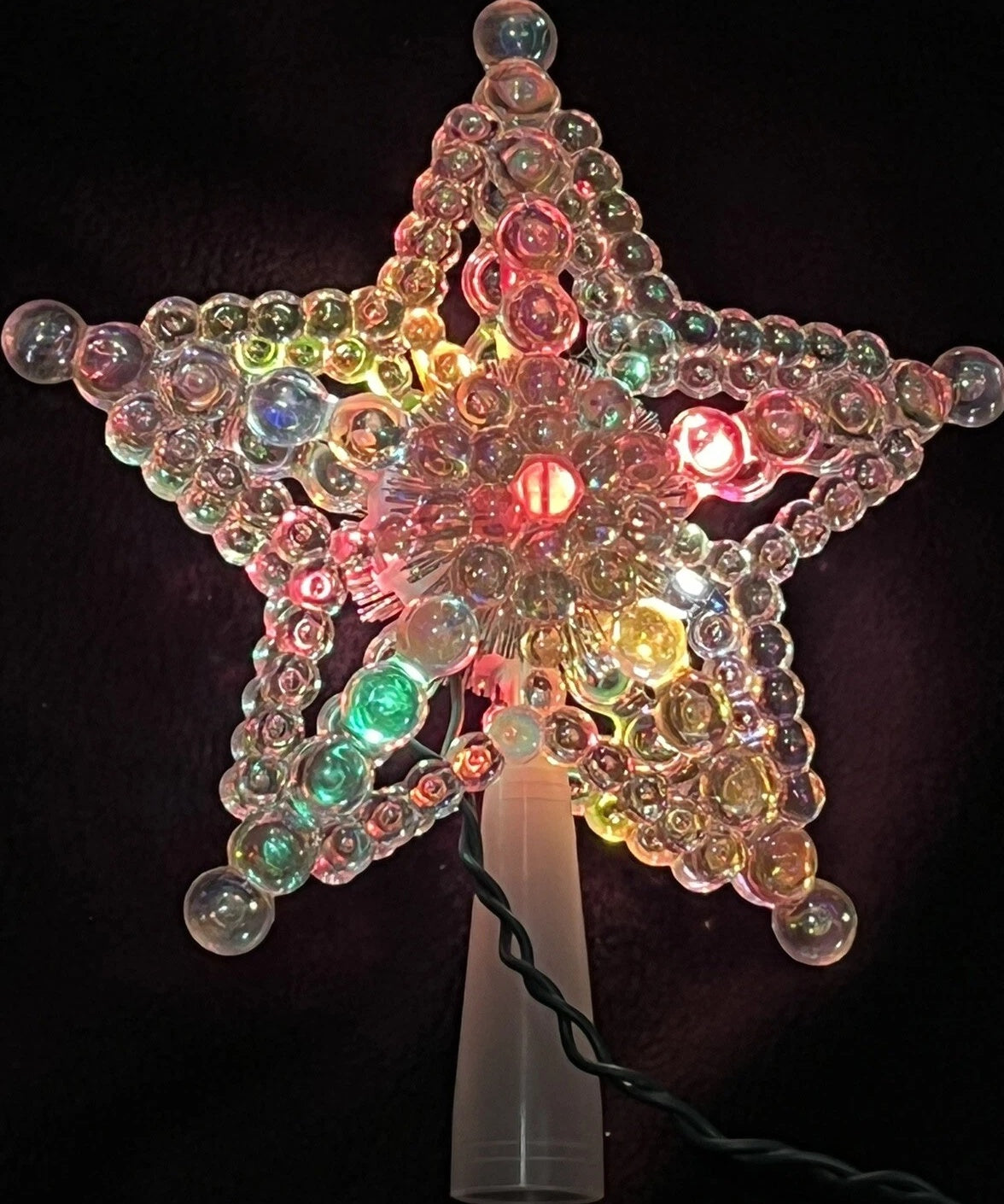 This image shows the iridescent beaded tree star with multi-colored lights.