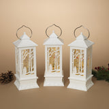 White lantern decoration with glitter and a woodland scene with a cardinal inside.