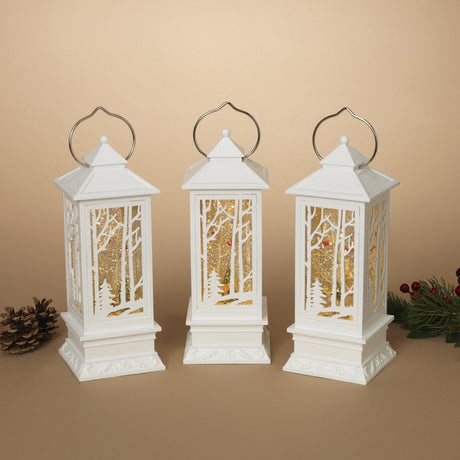 White lantern decoration with glitter and a woodland scene with a cardinal inside.