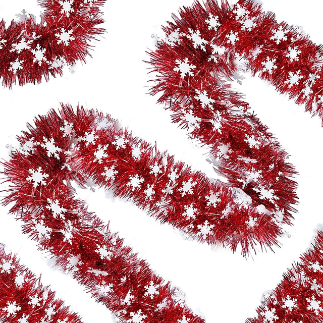 Red tinsel garland with white snowflake decorations on a white background