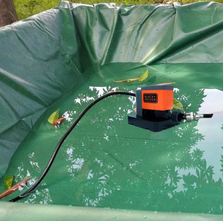 This is a lifestyle image showing the pump being used in the water on top of a pool cover.
