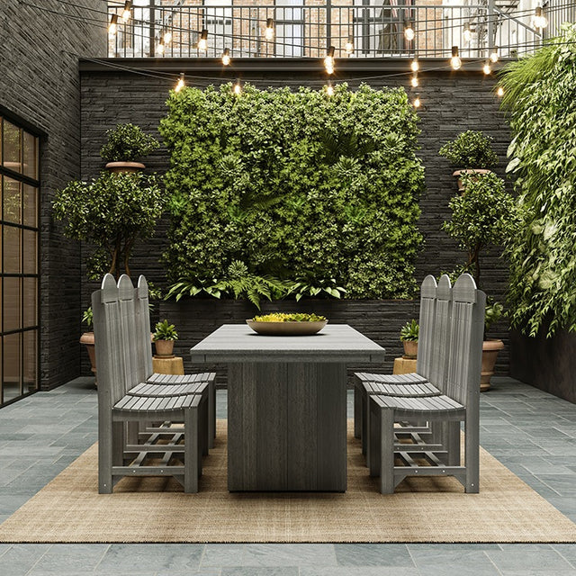 This is a lifestyle image showing the Coastal Gray colored dining table with matching chairs on an outdoor patio.
