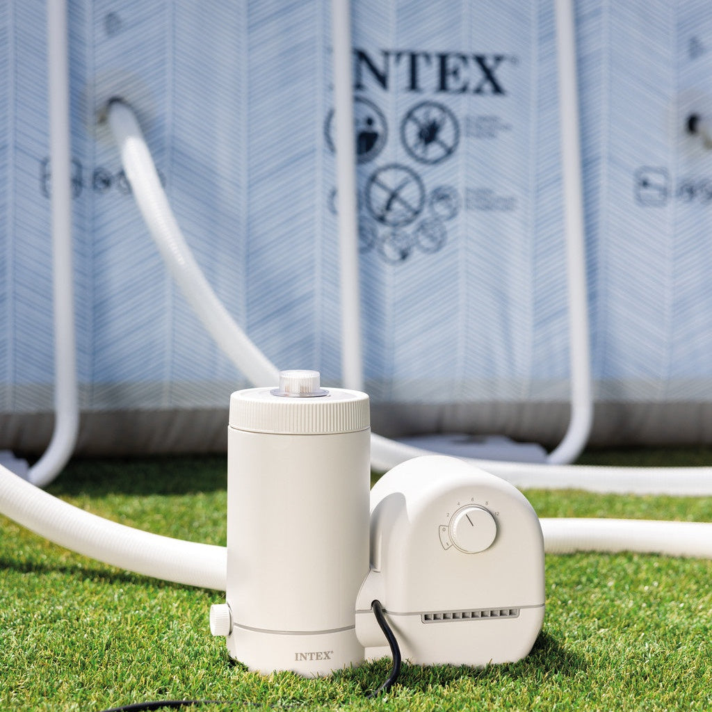 This is a lifestyle image showing the Intex filter on the ground in front of an Intex pool.