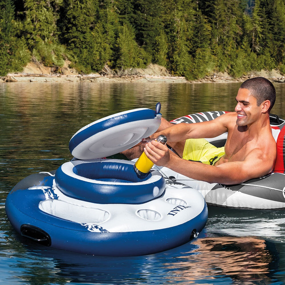 This is a lifestyle image showing a man reaching into the floating cooler and pulling out a water bottle.