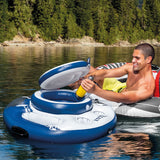 This is a lifestyle image showing a man reaching into the floating cooler and pulling out a water bottle.