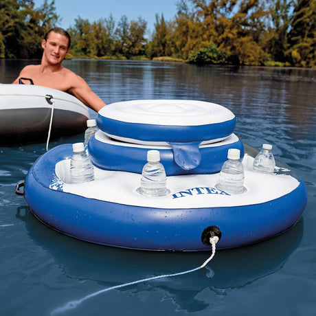 This is a lifestyle image showing a man using the rope to pull the floating cooler toward him on the water.
