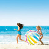 This is a lifestyle image showing two little girls playing with this jumbo ball on the beach.