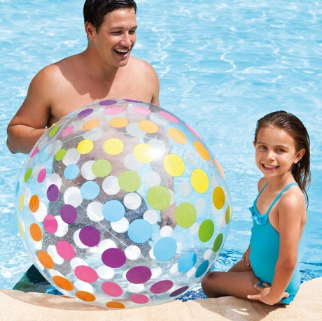 This is a lifestyle image showing a dad holding this beach ball while his daughter poses for the camera next to him in the pool.