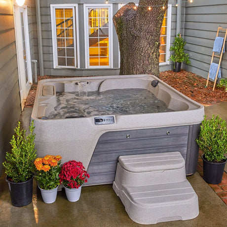 Hot tub in a covered outdoor area with plants and flowers.