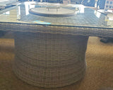 Square fire pit table. Made of woven materials. Features a lid. Underneath the lid is fire glass.