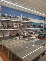 Various clearance outdoor patio tables and chairs on display at the Tinley Park Outlet store.
