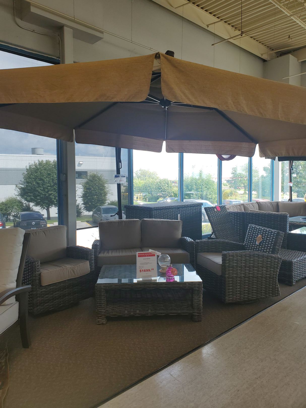Clearance outdoor furniture set with a beige cantilever umbrella displayed in our Tinley Park Outlet store.