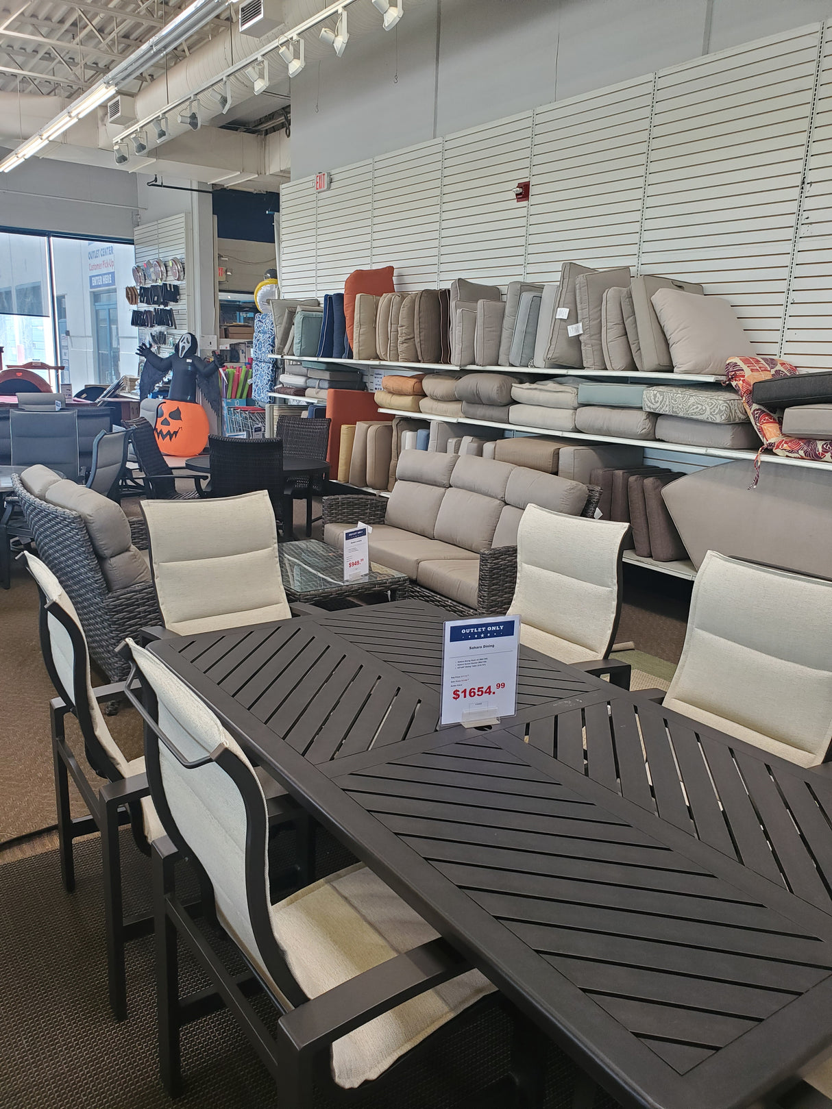 Clearance outdoor patio furniture sets on display in the Tinley Park Outlet store with various cushions .