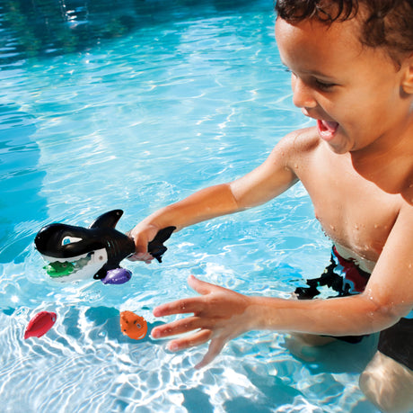Pool game shaped like a whale whose mouth opens up. Kids try to use the whale's mouth to swallow up the little toy fish.