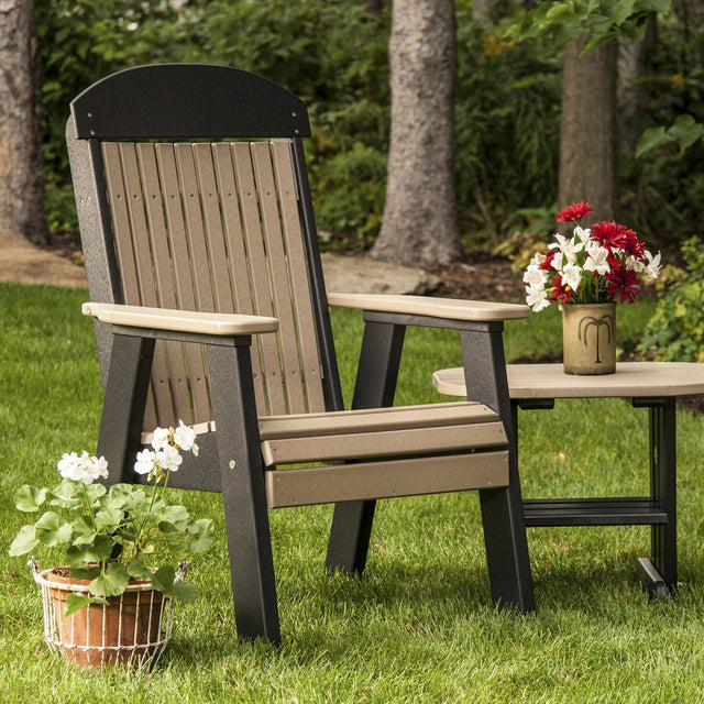 This is a lifestyle image showing the Weatherwood and Black colored bench on a grassy patio next to a matching table.