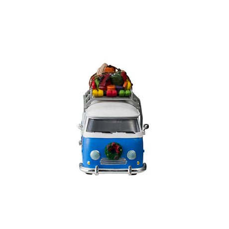 Plastic table accent for a Lemax display. Designed to look like a blue and white Volkswagen shuttle bus. The sides of the bus read "Mountain Side Shuttle Bus" and features a mural of someone skiing down a snowy hill surrounded by trees. There's a wreath on the front bumper. There's a ladder on the side leading up to the roof o the bus that's holding a bunch of ski equipment and luggage.
