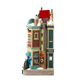 Resin building facade for a Lemax display. Designed to look like a bunch of store fronts. Signs read: "Fay's Flowers & Bouquets," "The Burger Cafe," "Jolly Toys & Games," "Quilter's Island," Sweet Spot" and "Hot Fresh Coffee at the Christmas Bazaar!" There are flowers everywhere and a billboard on the roof advertising a visit with Santa.