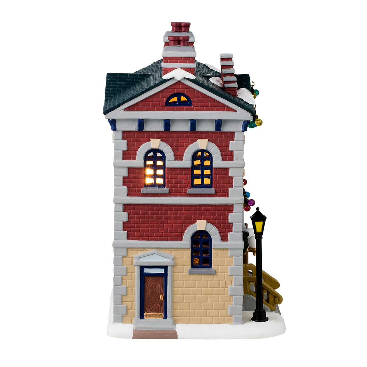 Porcelain lighted building for a Lemax display. Designed to look like a red, yellow and gray brick police precinct office. The roof and sidewalk has snow on it. There are multi-colored lights hanging from the roof. The windows have wreaths and there's a car coming out of the side garage.