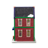 Porcelain lighted building for a Lemax display. Designed to look like a brick building with snow on the roof and the sidewalk. The signs read "The Tobacco & Gift Emporium" and "Special Today: Cheroots 2 for 1." There's a decorated wreath on the door. Through the window in the front, you can see a man buying cigars from a man behind a counter.