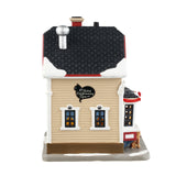 Porcelain lighted building for a Lemax display. Designed to look like a Victoria-era house that's been turned into a cat grooming office. There's snow on the roof and the sidewalk. There are different colored cats all over the place. Inside the window, you can see one of the groomers hard at work. There are red ribbon accents and two small potted trees.