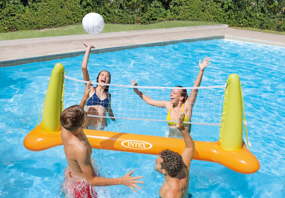 This is a lifestyle image showing four people playing volleyball in the pool.