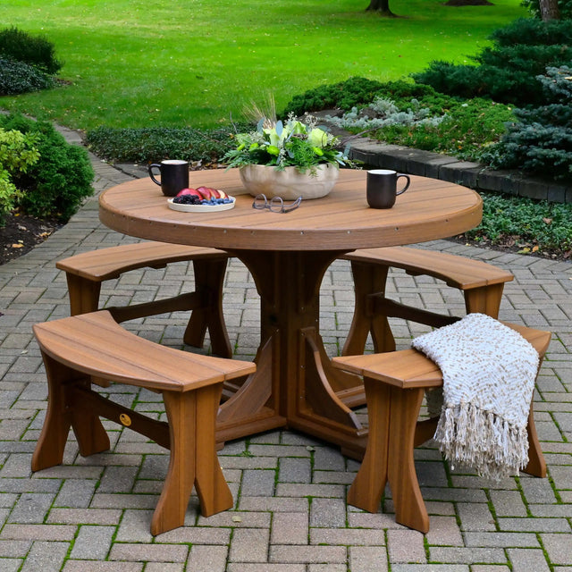 This is a lifestyle image showing the Antique Mahogany round dining table surrounded by matching benches.